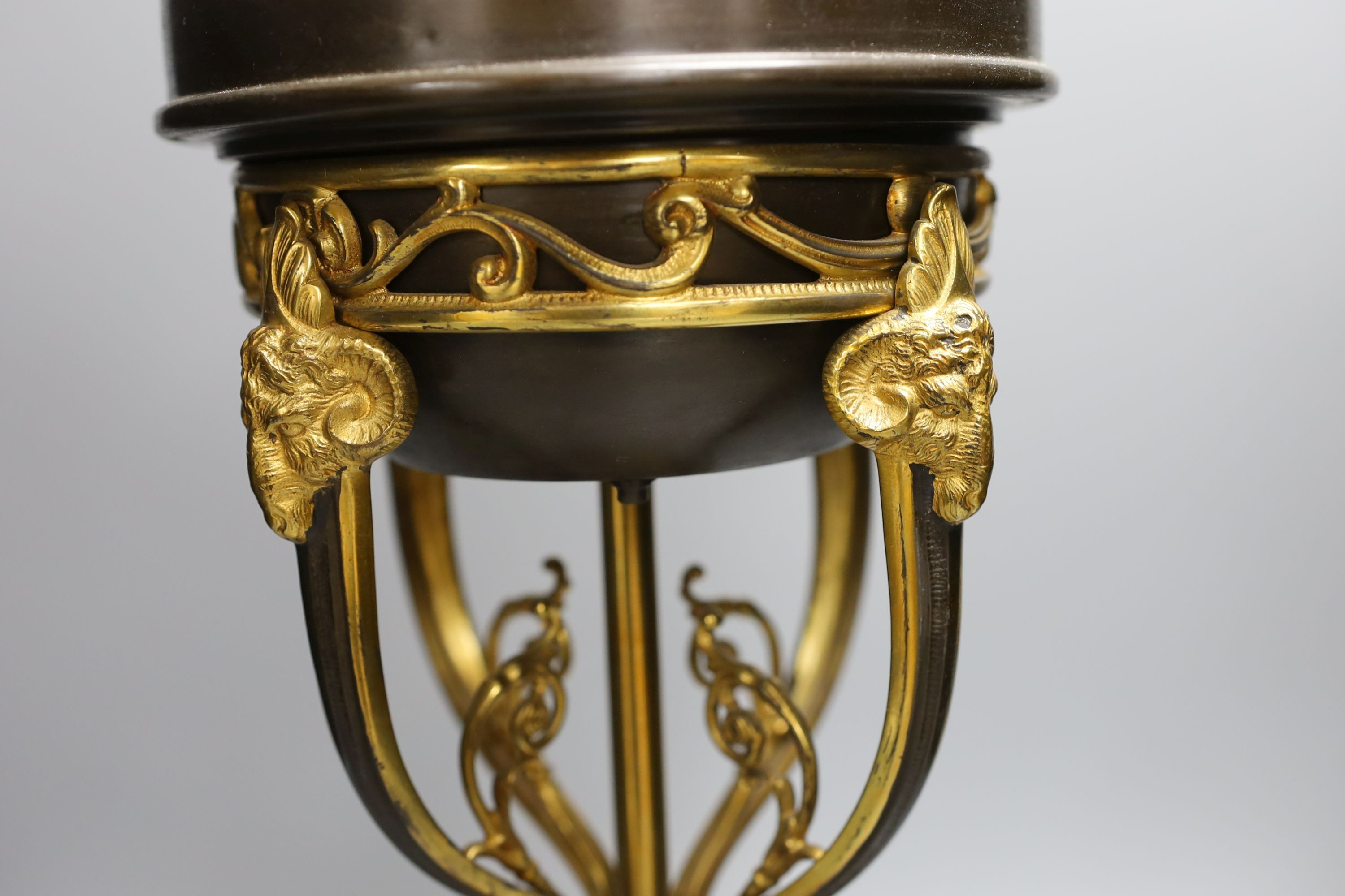 A gilt metal ‘rams head and hoof’ monopodia oil lamp, converted to electric, total height 72cm